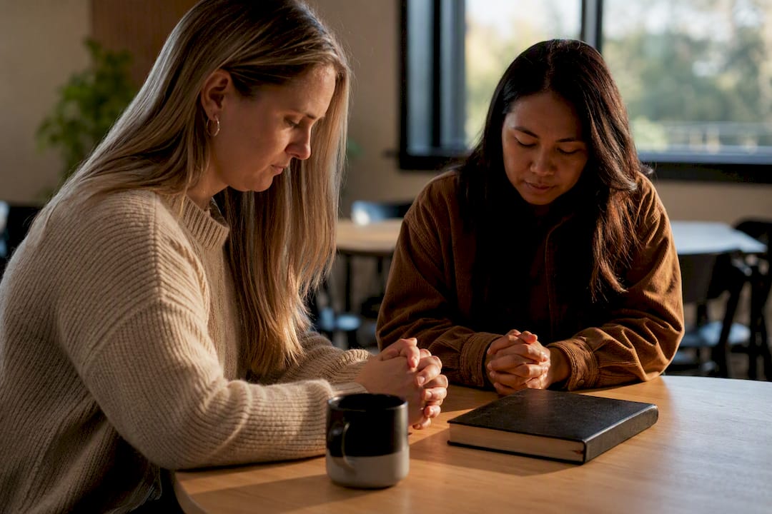 Two friends praying together for guidance