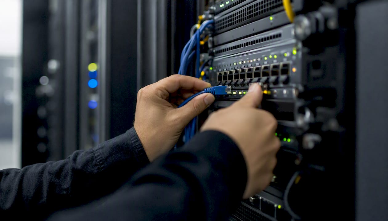 Hands configuring network switch in private cloud room