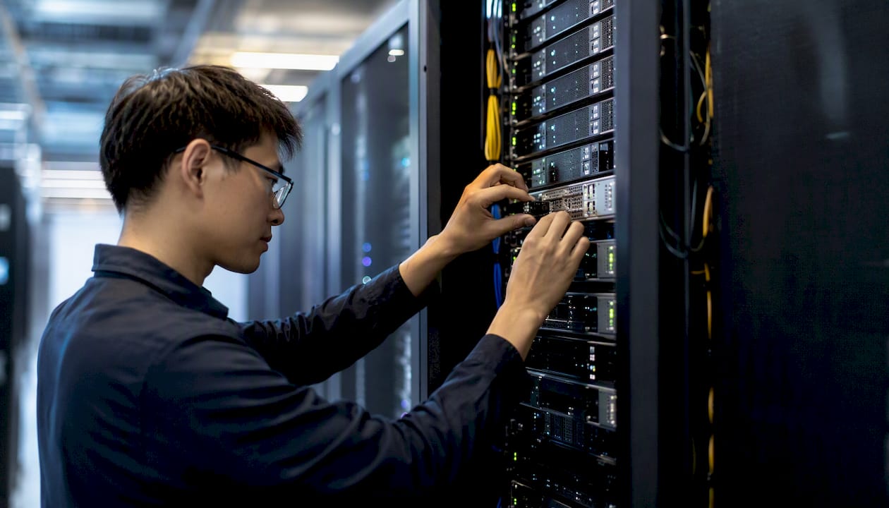 Hands adjusting hardware controls on server rack