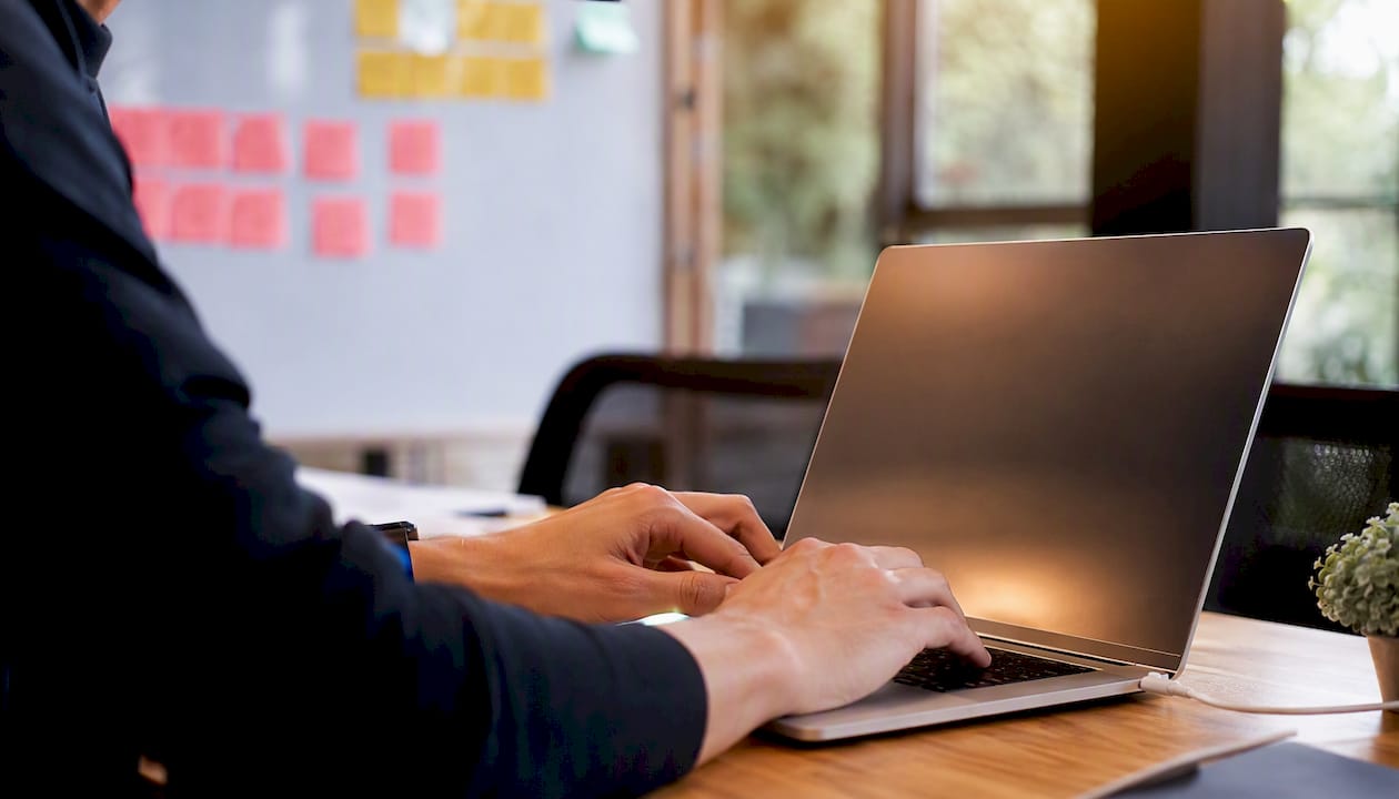 Hands configuring telemetry collector on laptop