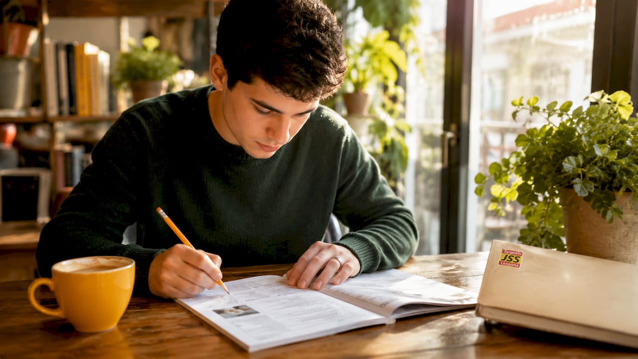 Hands with pencil over language test booklet