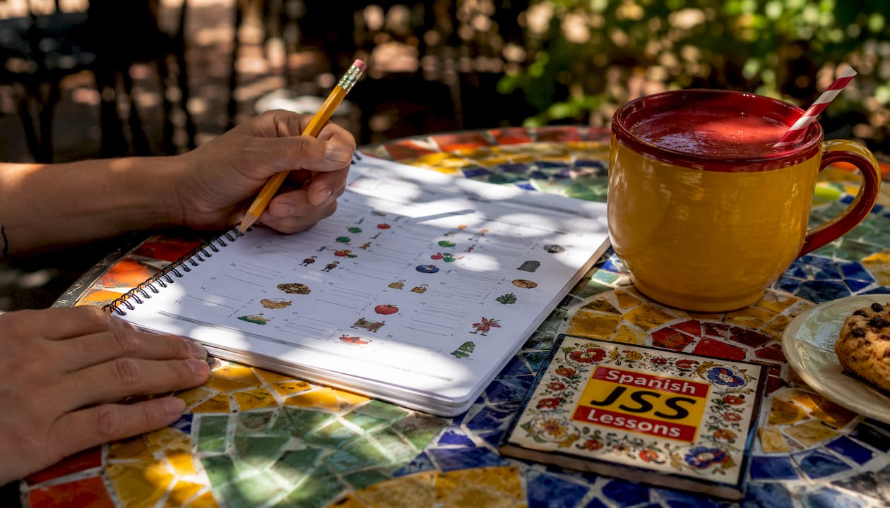 Hands doing Spanish workbook exercises