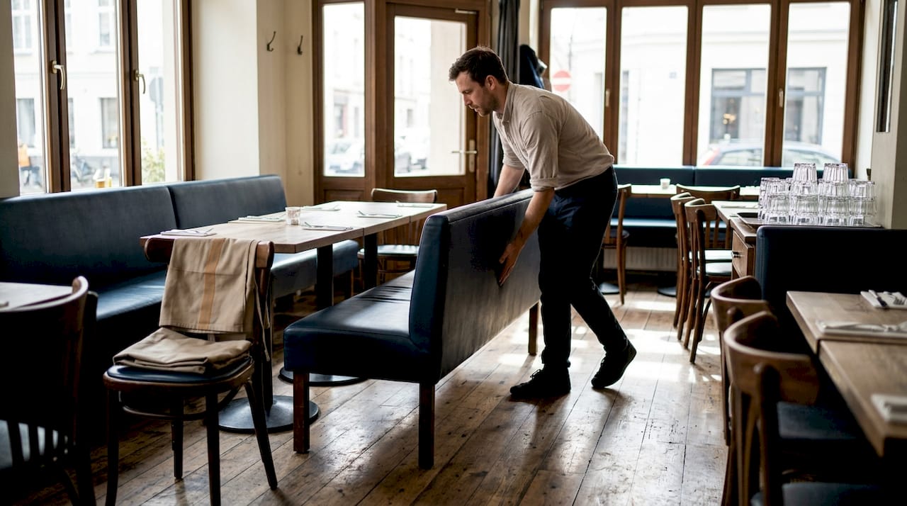 Osoblje preuređuje modularne stolove i sjedenje u restoranu kako bi prilagodilo prostor gostima.