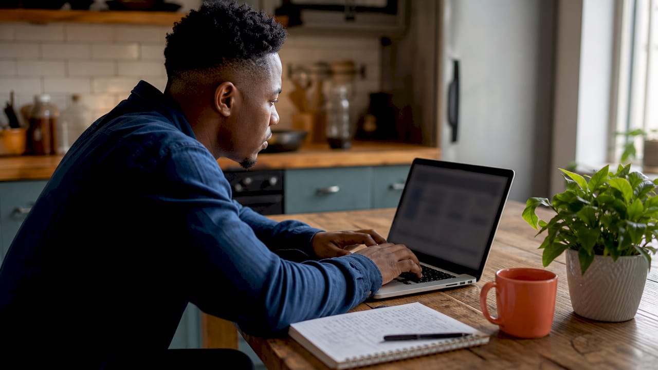 Man using laptop for insurance comparison at home office