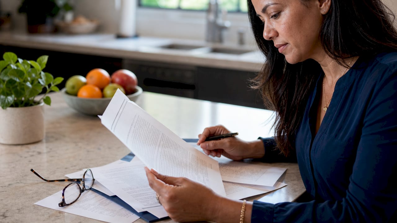 Hands holding insurance endorsement documents on desk