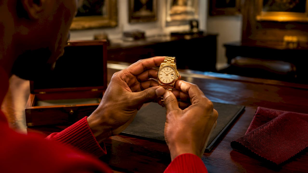Hands inspecting vintage watch in auction preview