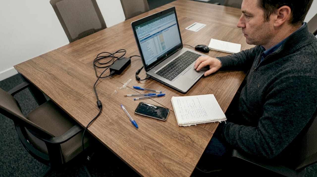 Un chef d’entreprise gère la facturation de sa PME sur son ordinateur.