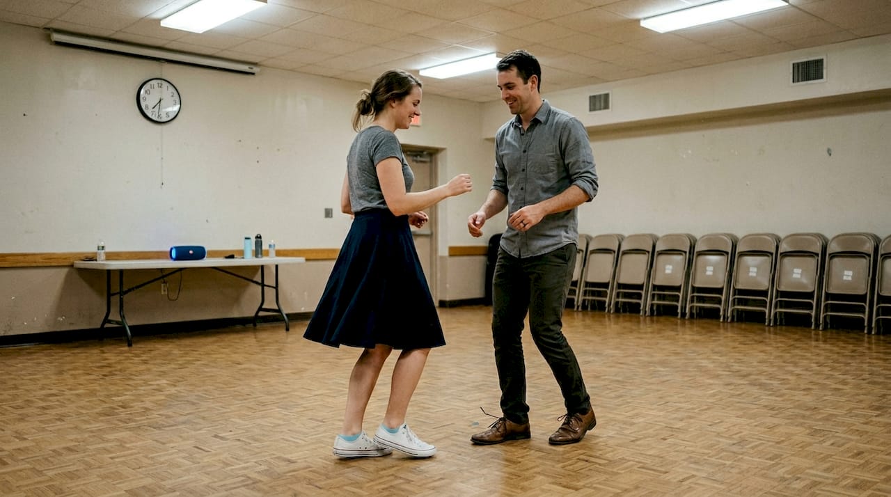 Bride and groom rehearse salsa steps community hall