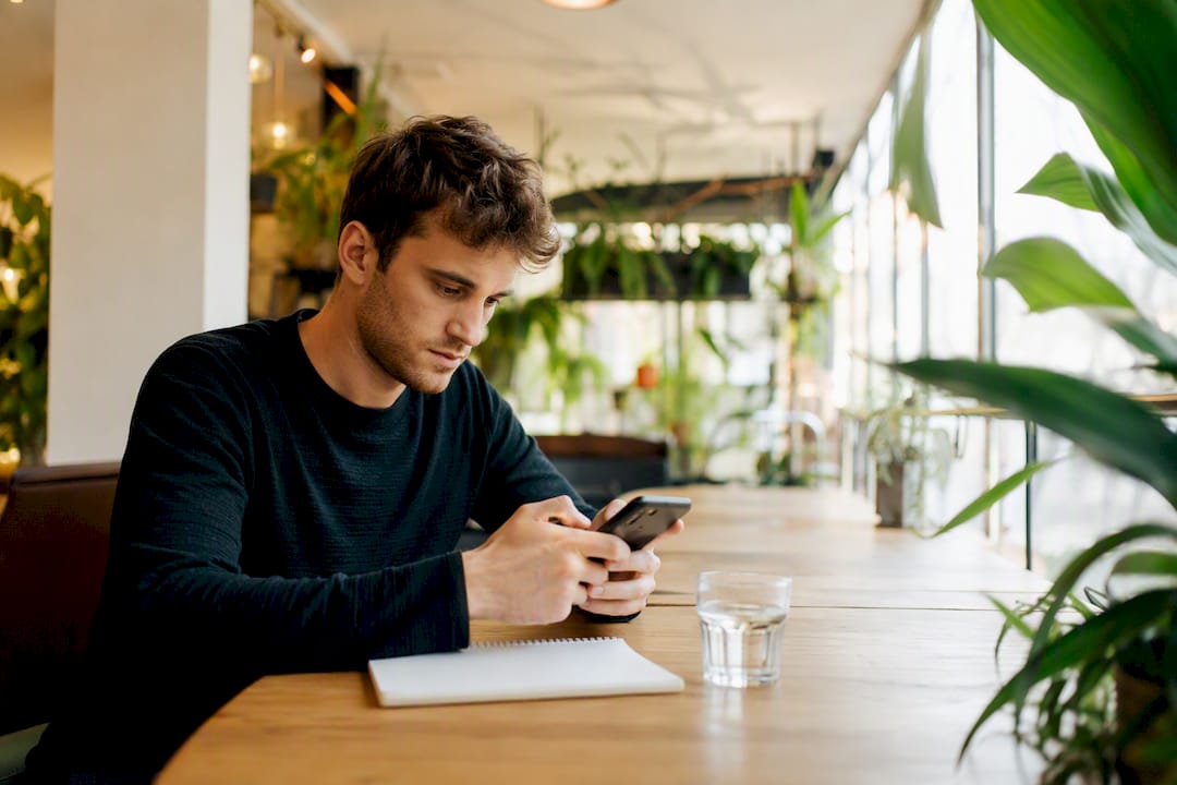 Eine Person vergleicht Bewertungen auf Tablet und Smartphone.