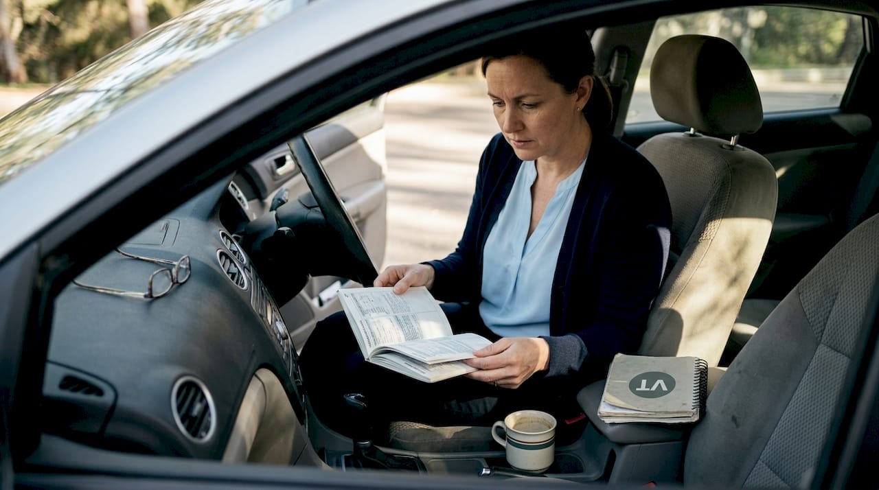 Woman studies maintenance log, VIN in car