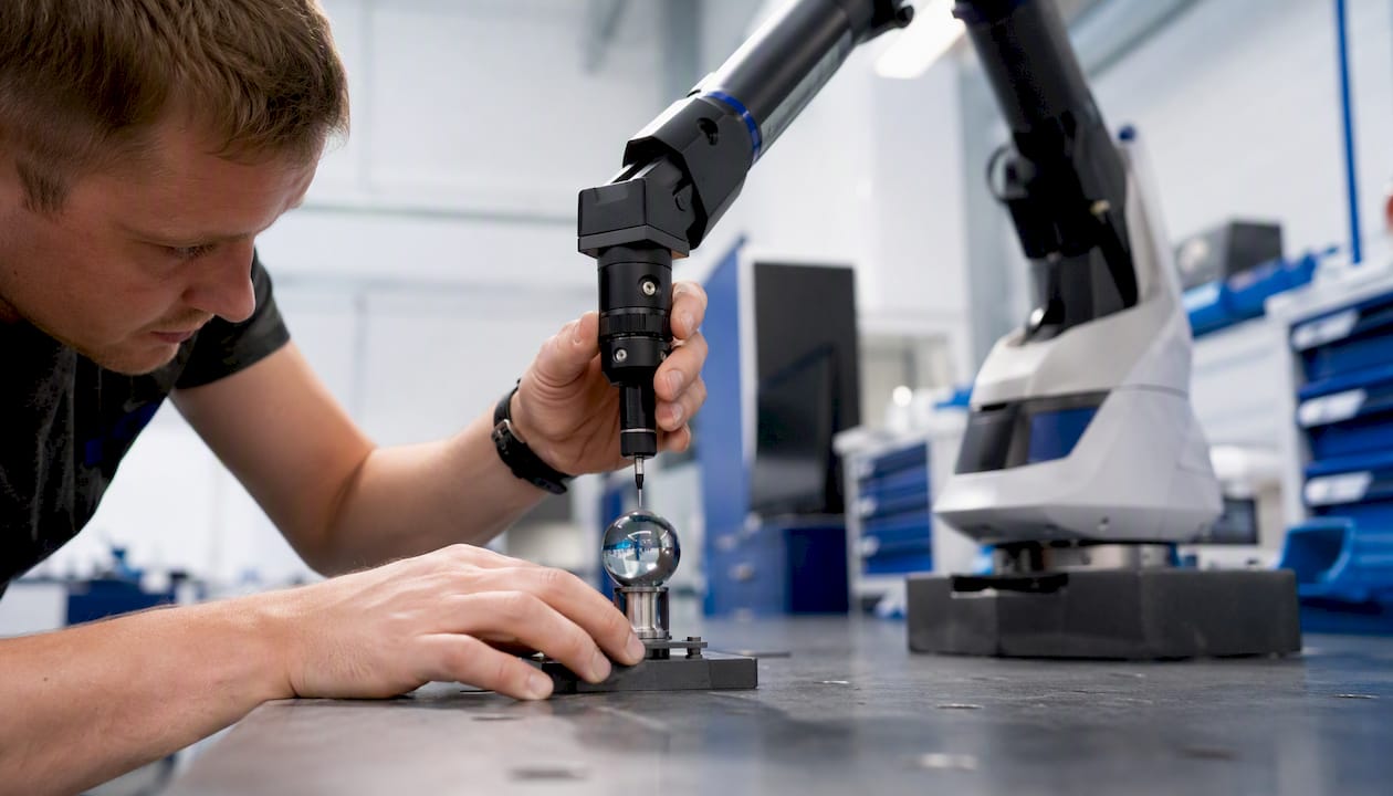 Händer justerar en 3D-scanner med hjälp av en referenskula