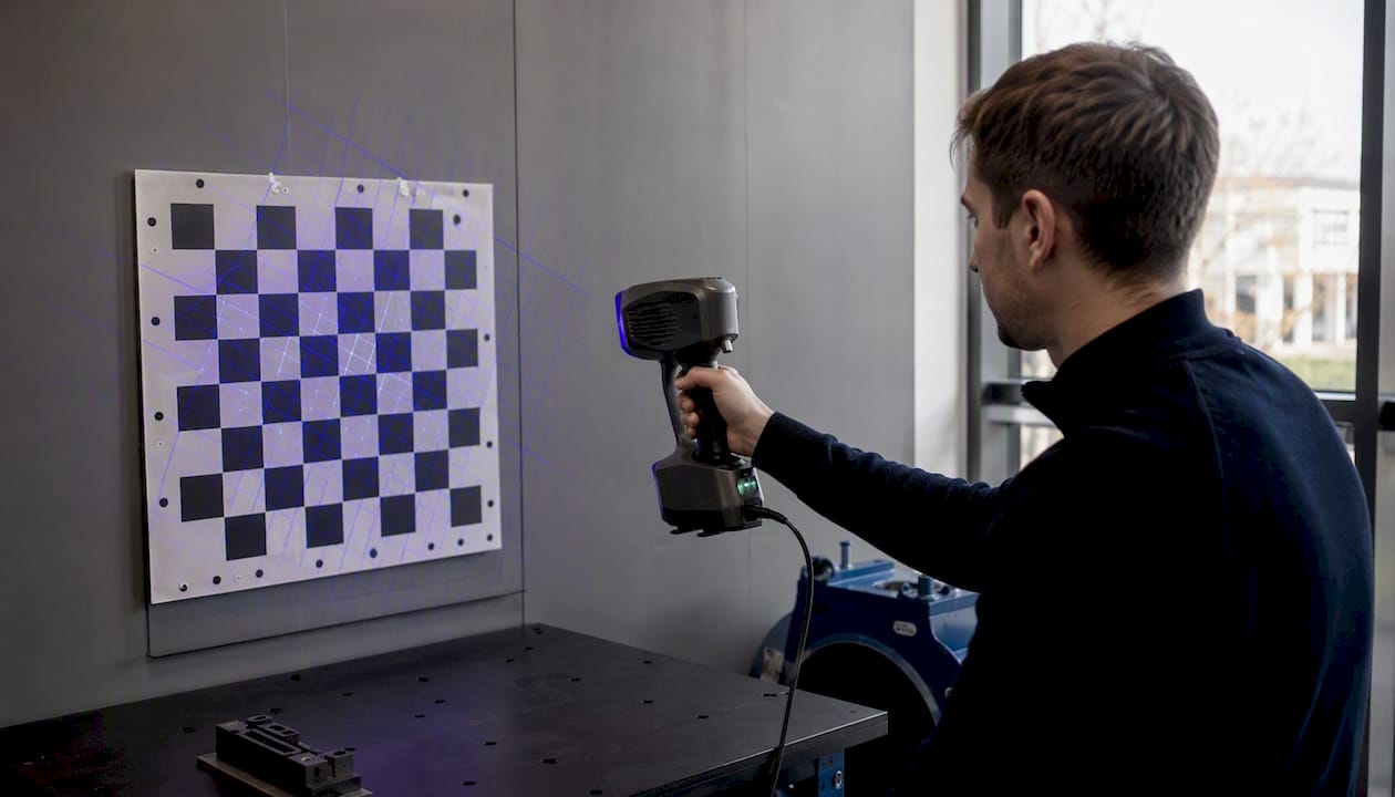 Händer som justerar en handhållen 3D-skanner med strukturerat ljus
