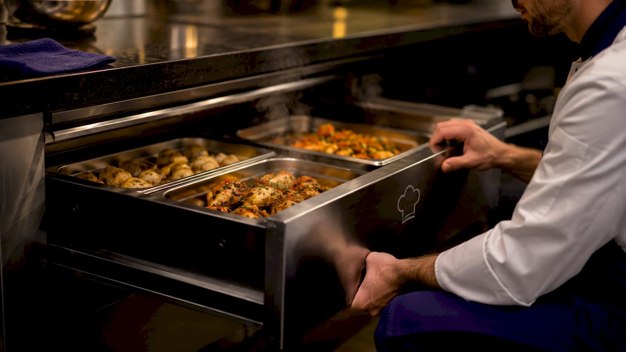 Hot cooked food inside warming drawer containers