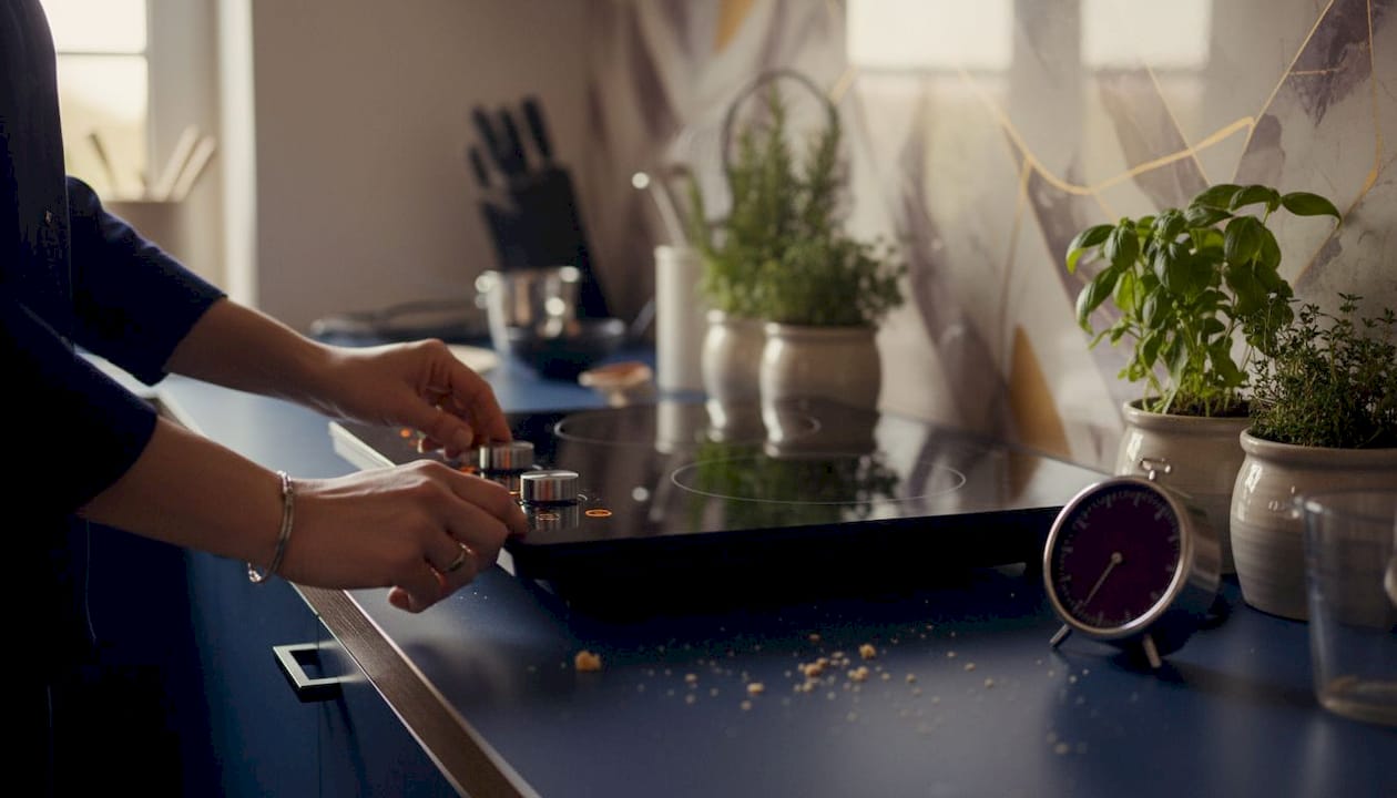 Hands adjusting portable induction cooktop controls