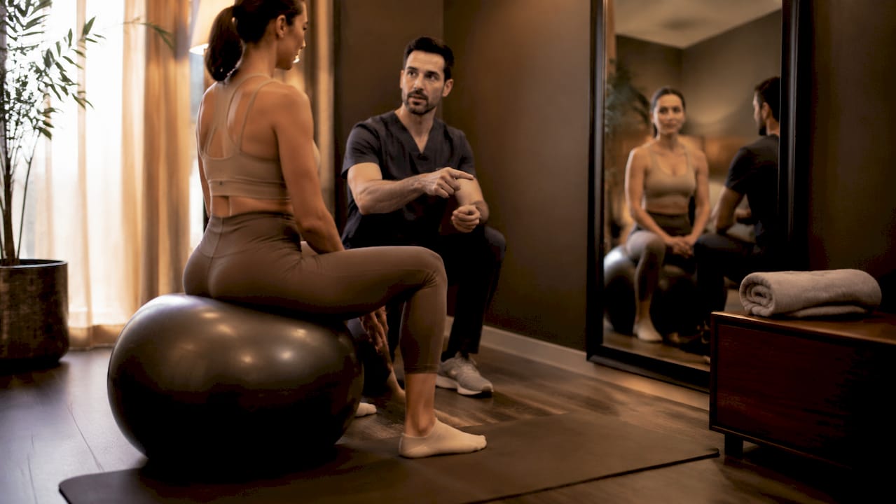 Physical therapist correcting posture for patient