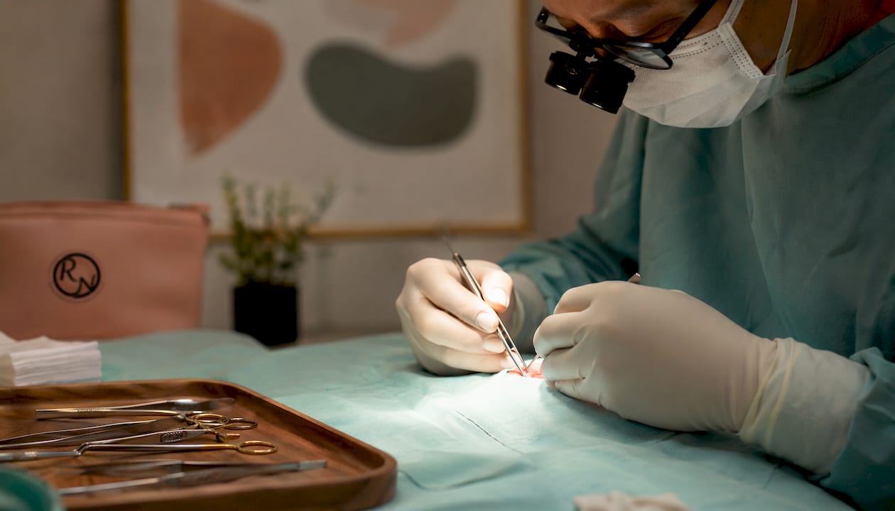 Surgeon's hands performing facial reconstruction surgery
