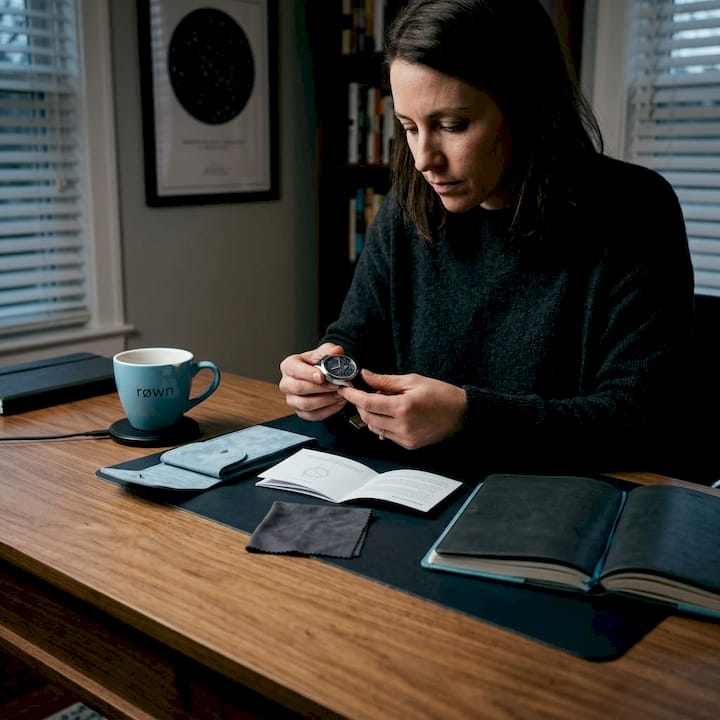 Woman inspecting custom star map watch at desk