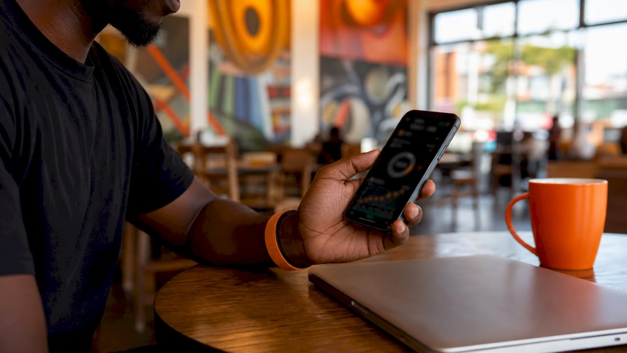 Hand holding smartphone with solar app dashboard close-up
