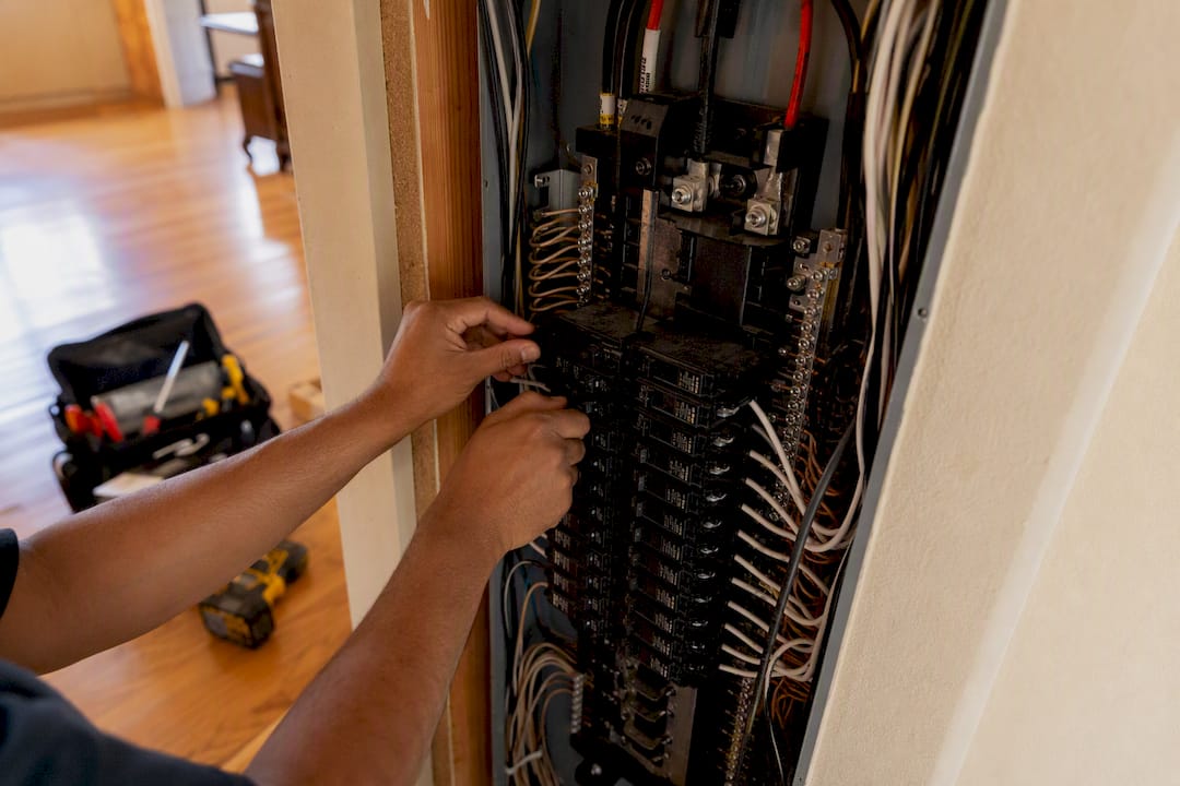 Electrician hands inspecting home electrical panel