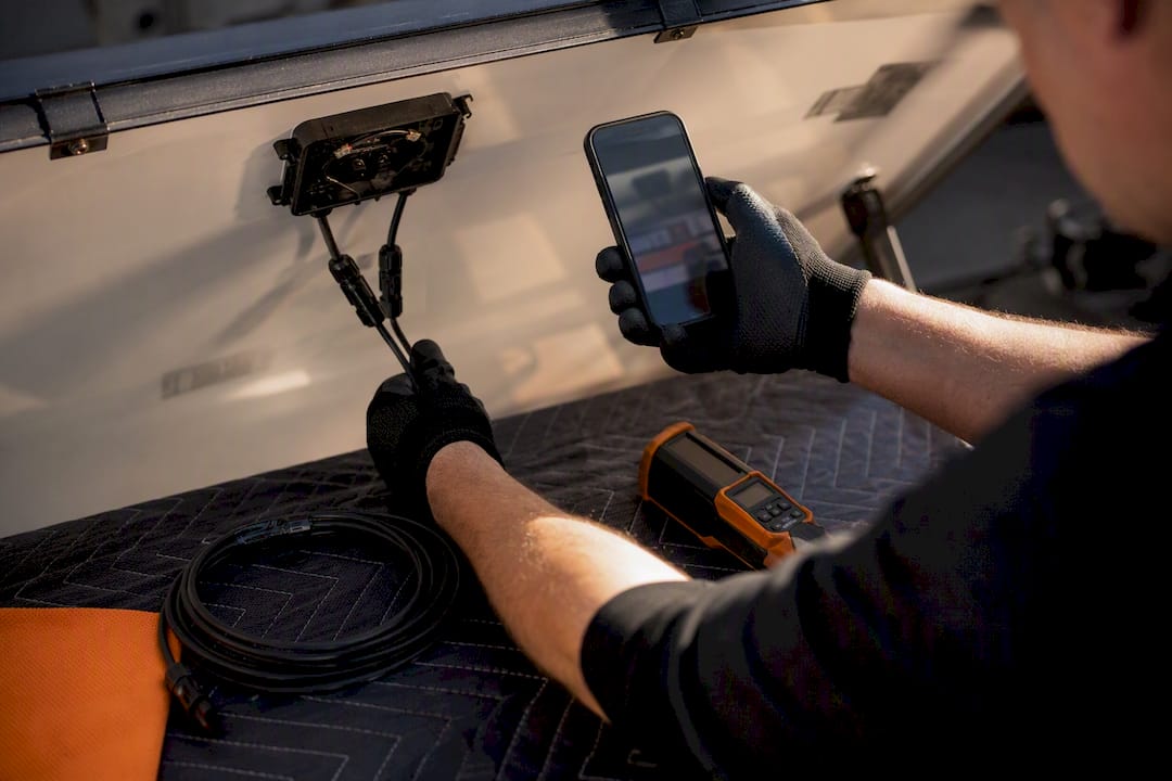 Technician documenting solar panel wiring before removal