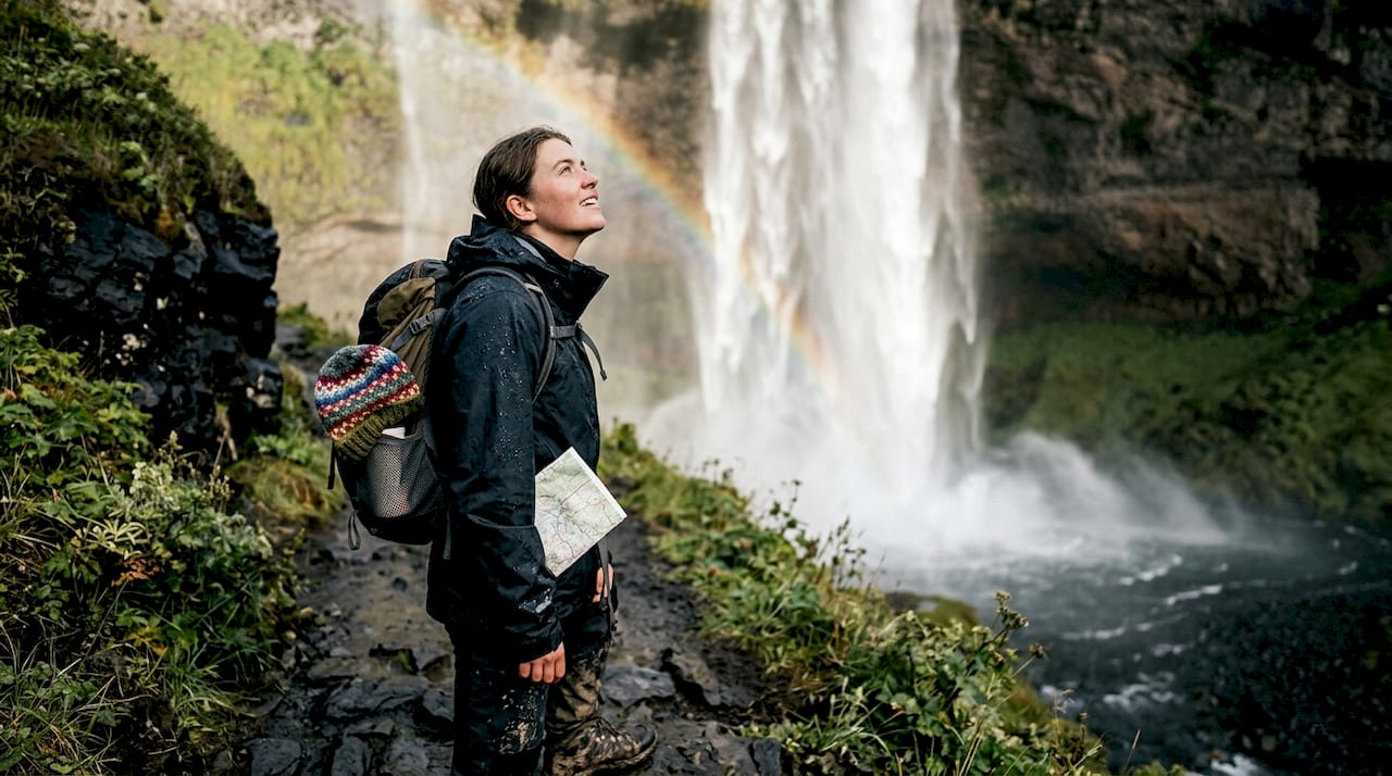 Hiker near Skógafoss waterfall in May