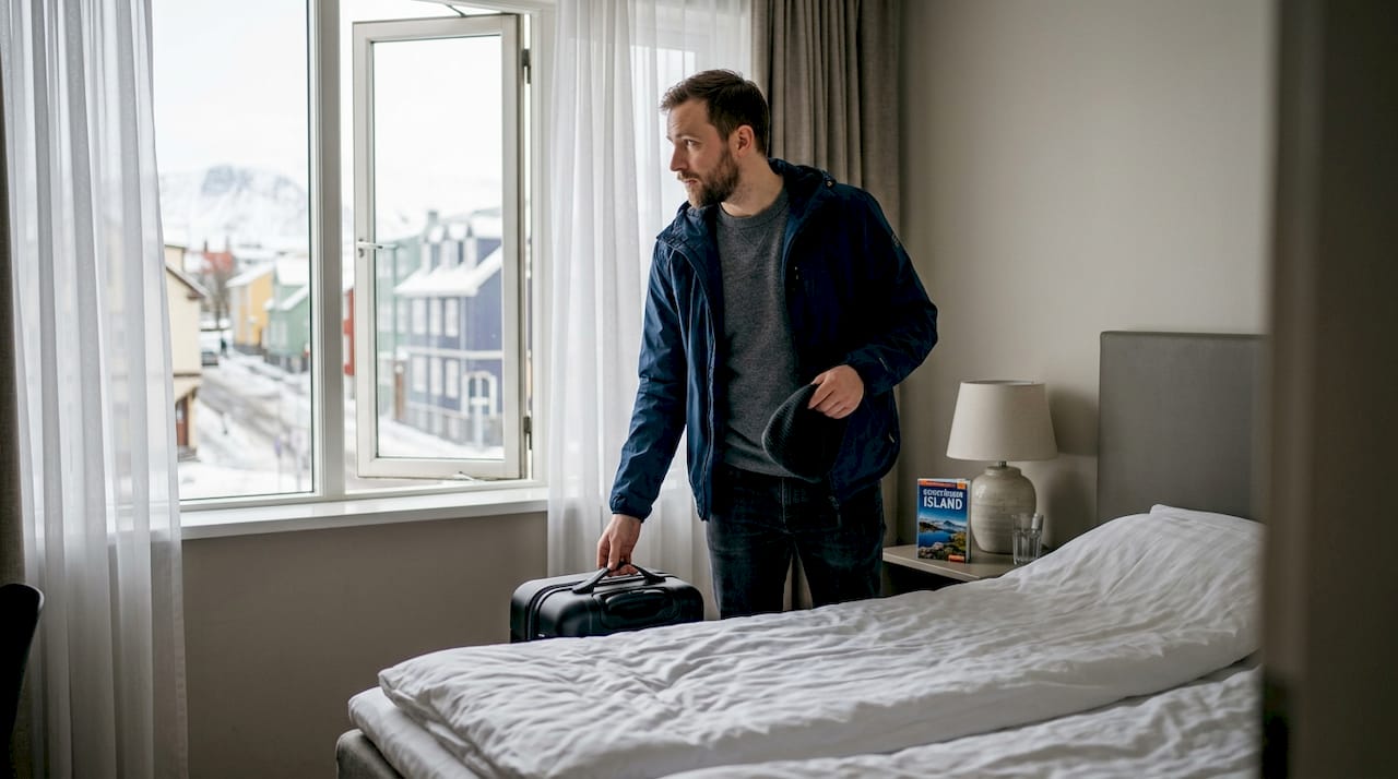 Ein Reisender packt in seinem Hotelzimmer in Reykjavik den Koffer aus.