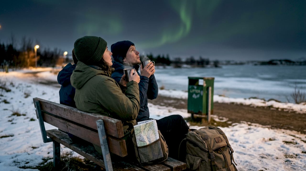 Travelers watching aurora at Lake Mývatn