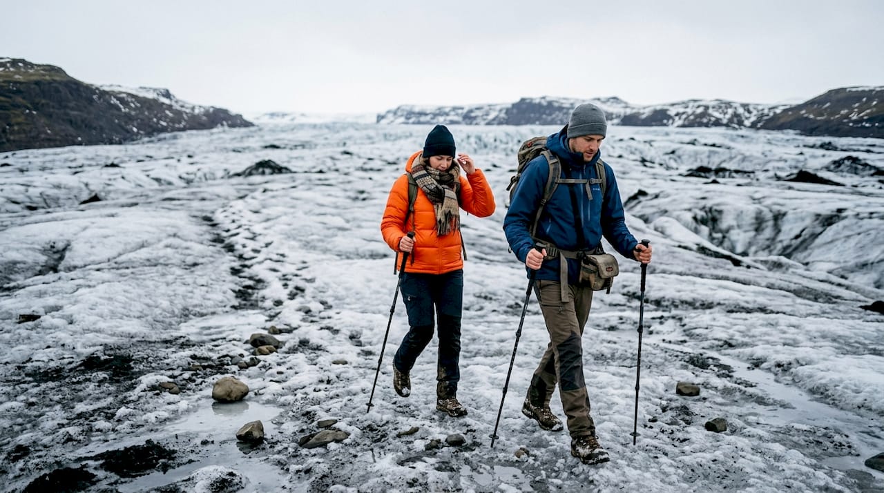Una coppia si avventura insieme tra i ghiacci di un ghiacciaio islandese