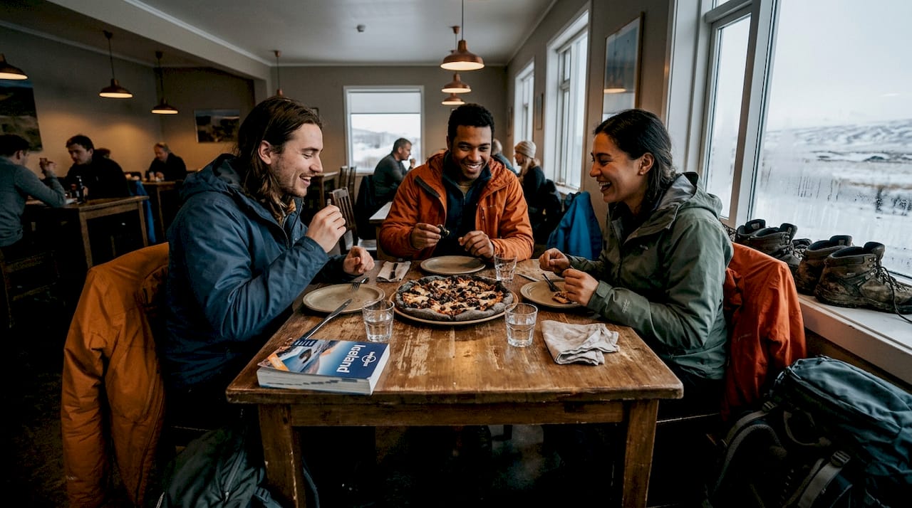 Un grupo de viajeros disfrutando de una pizza juntos en un hostel de Islandia