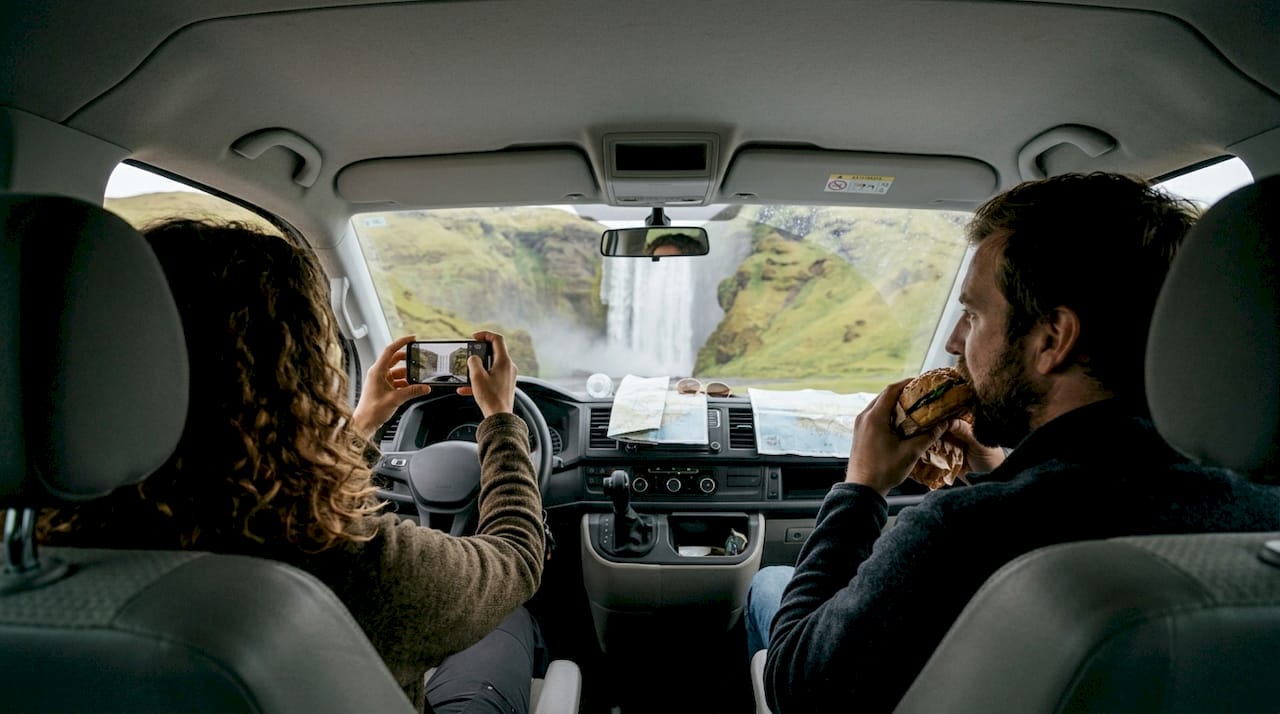 Virée entre amis en van devant une impressionnante cascade dans le sud de l’Islande