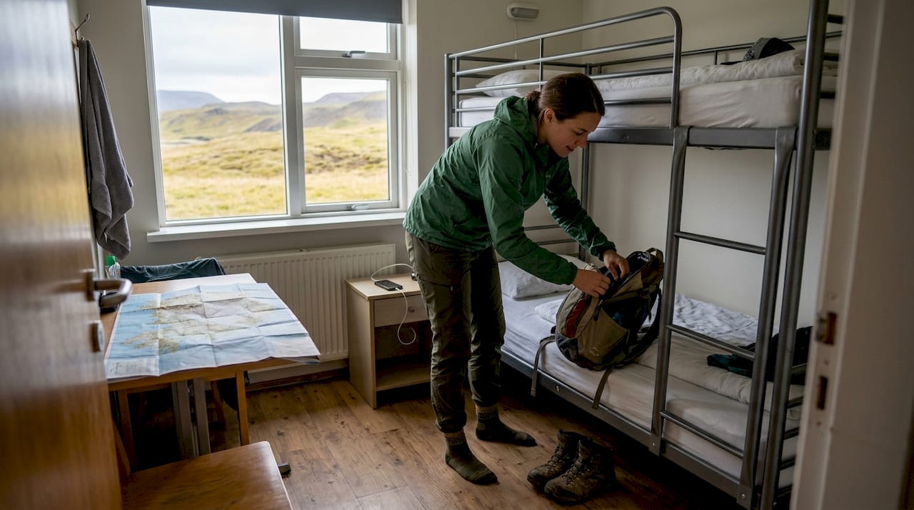 Viajero acomodando su equipaje en una habitación de hostal en Islandia
