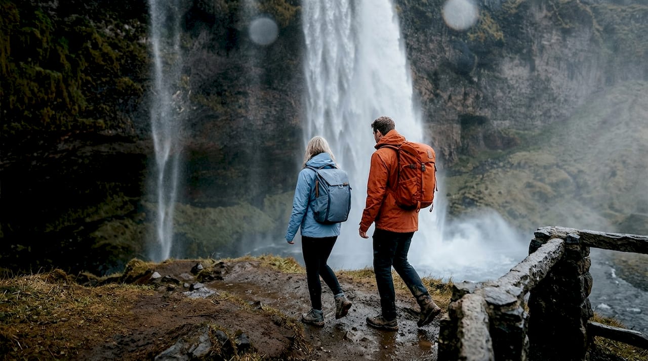 Tourists hiking muddy path behind Seljalandsfoss