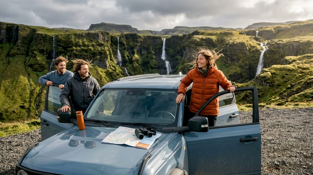Travelers beside SUV on Iceland South Coast