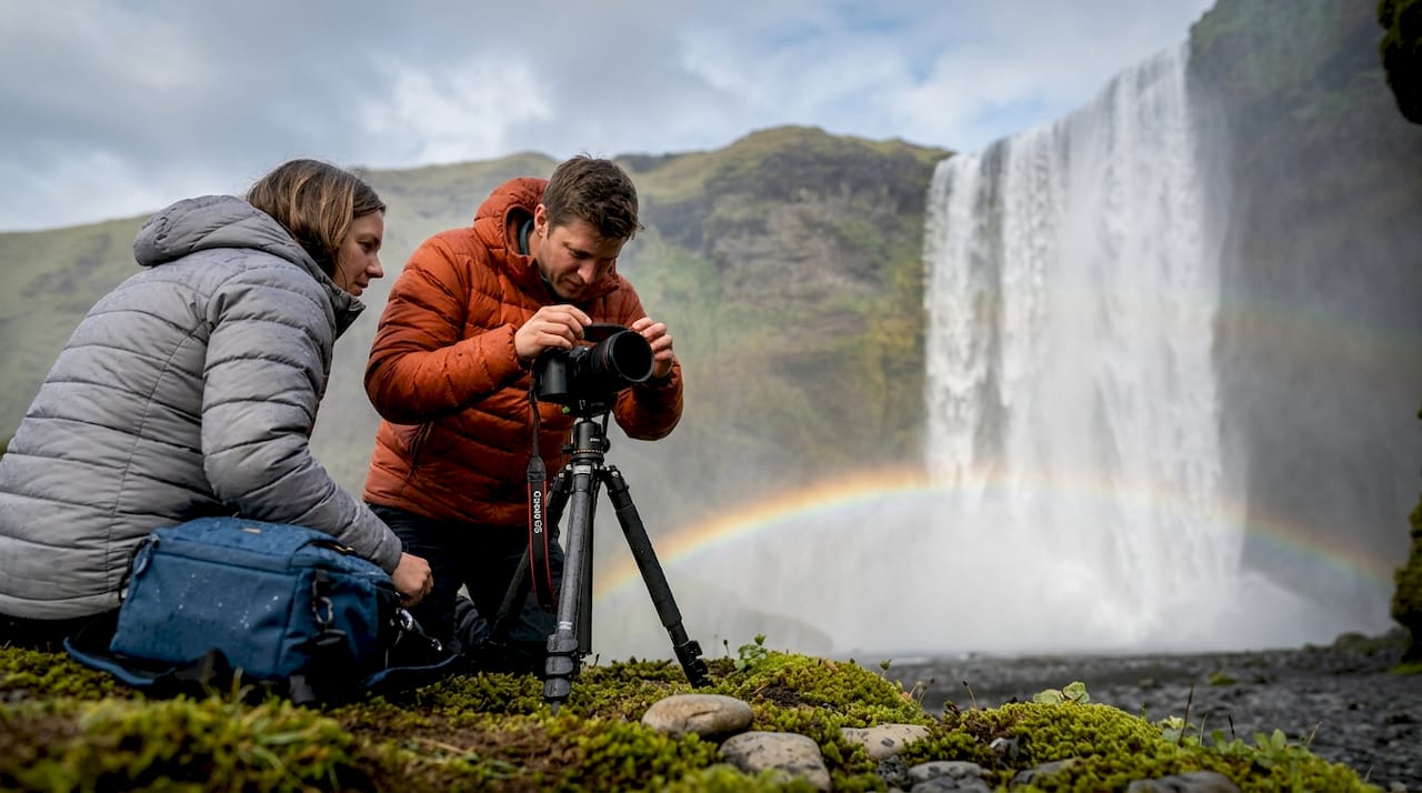 Photographers at Skógafoss waterfall with rainbow