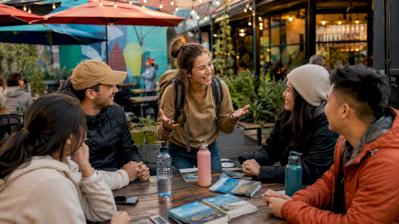 Solo traveler engaging with group in hostel common area