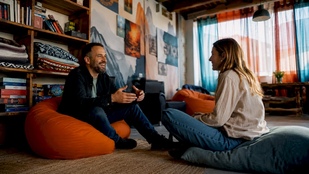 Solo travelers socializing in a hostel dorm room