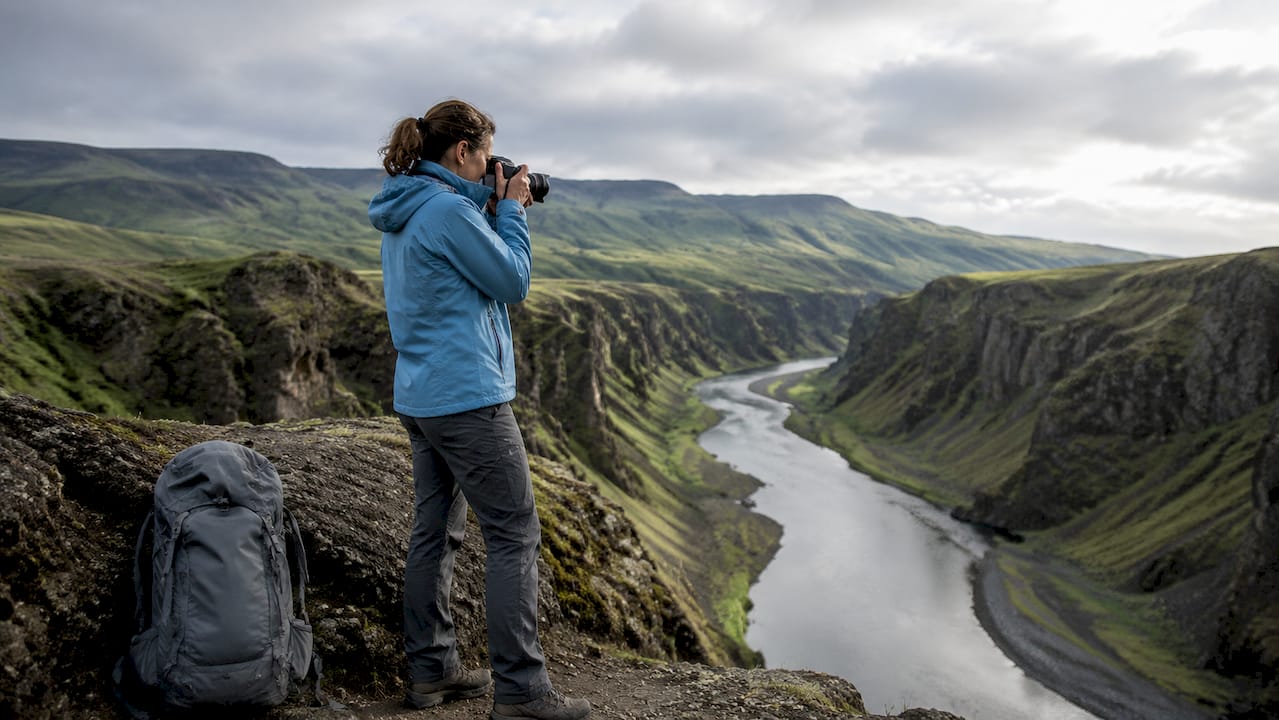 Una mujer contempla la serenidad de un paisaje islandés, disfrutando de la tranquilidad que le ofrece la naturaleza.