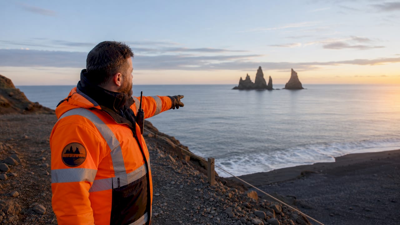 Un vigilante indica el área segura en la playa de Reynisfjara