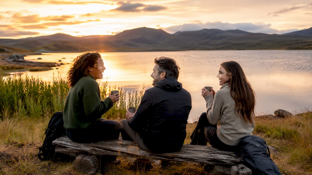 Travelers socializing outdoors at picnic table