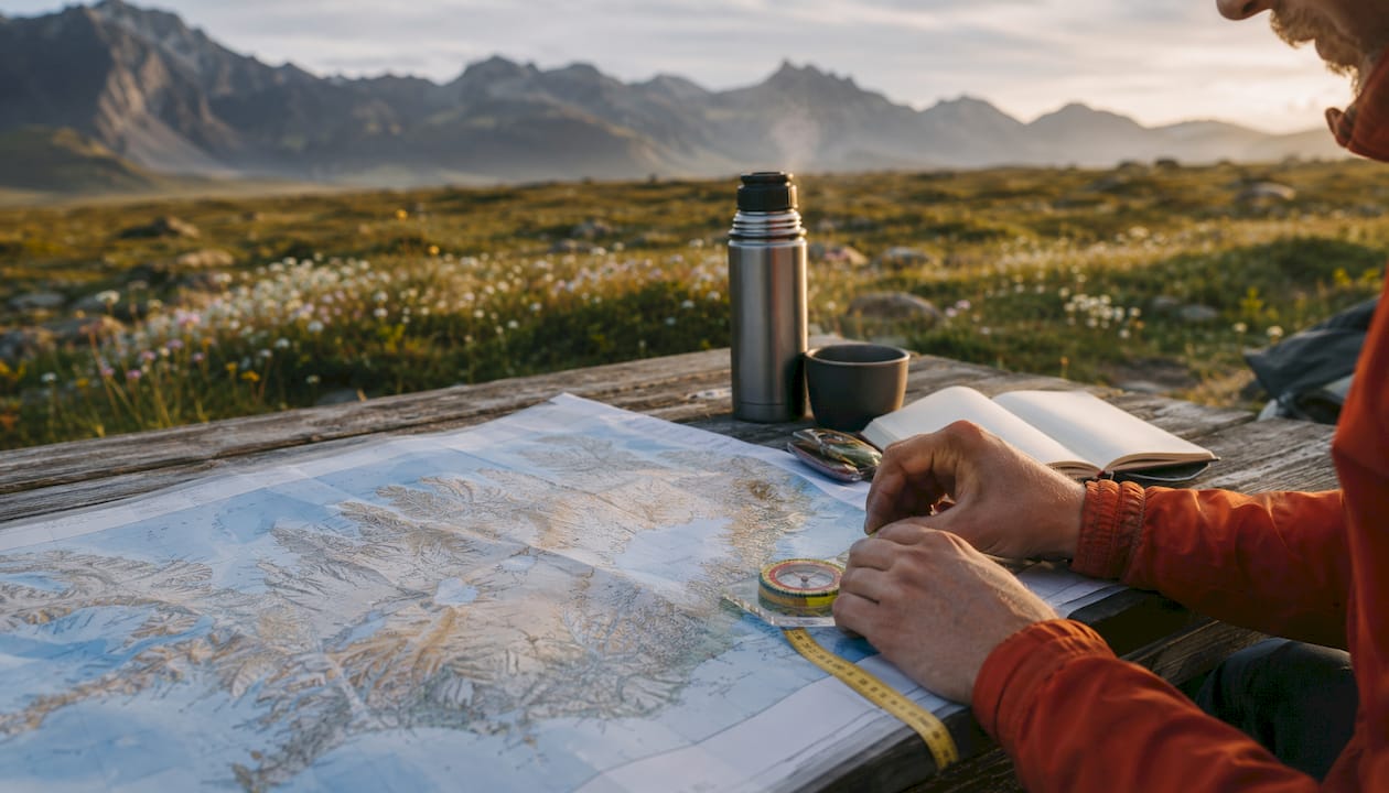 Hands holding compass over Iceland map