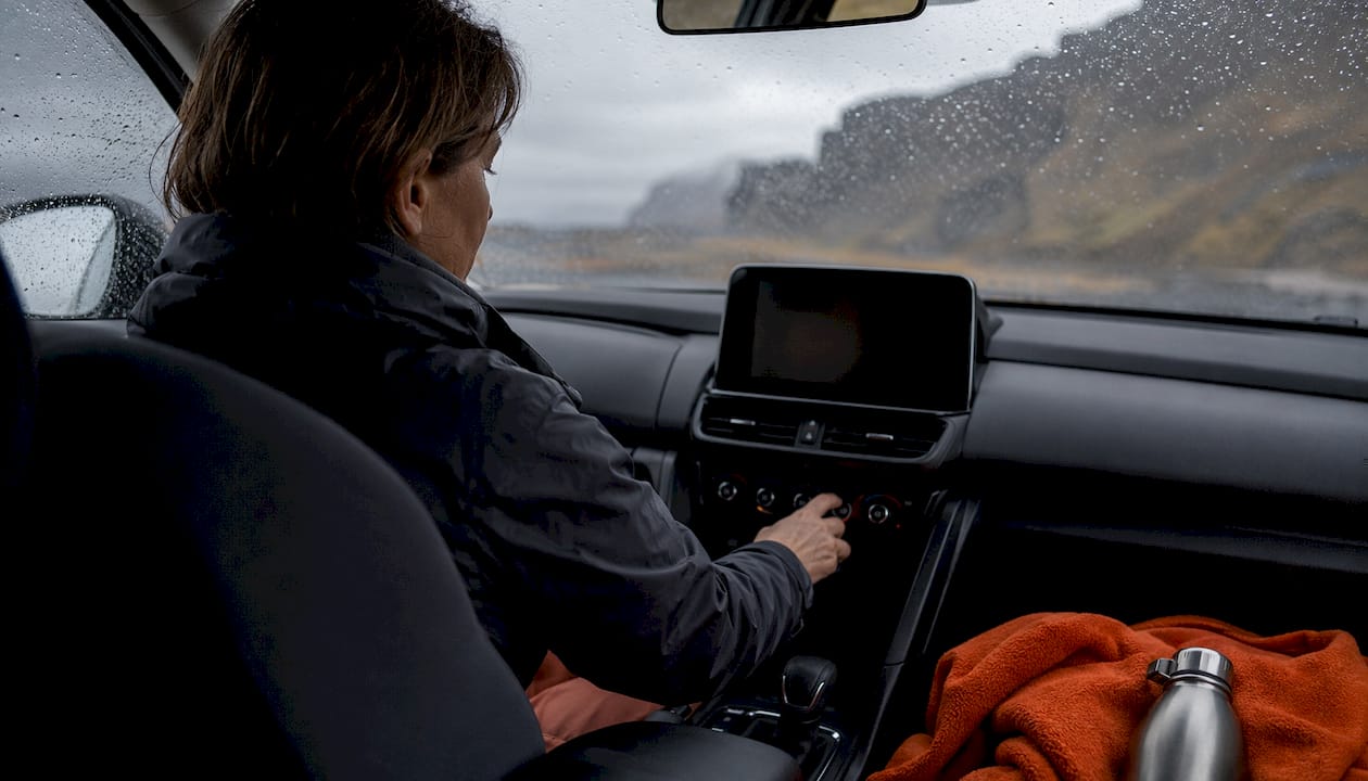 Driver adjusting car settings in Iceland rental