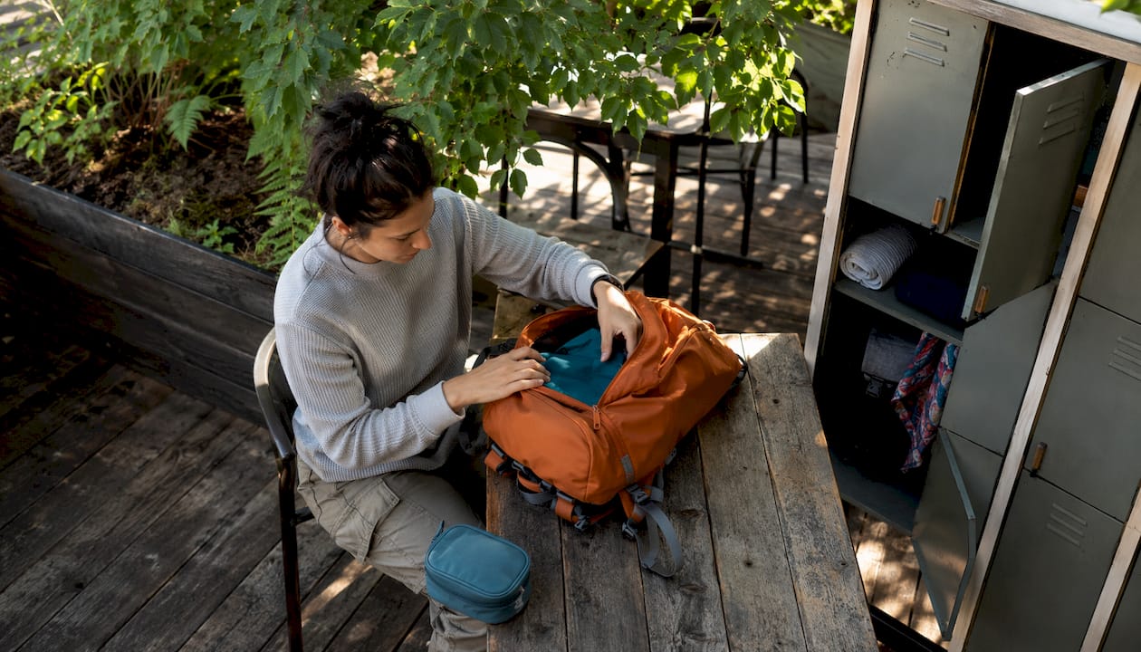 Traveler packing belongings near hostel locker