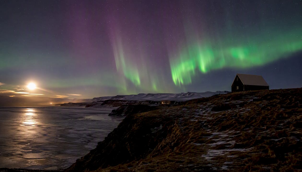 Northern lights above Icelandic countryside barn