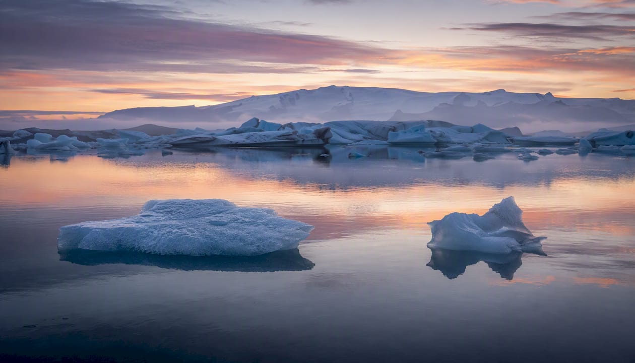 Glacier lagoon with floating icebergs at sunrise