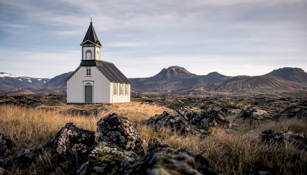 White timber church with lava field backdrop