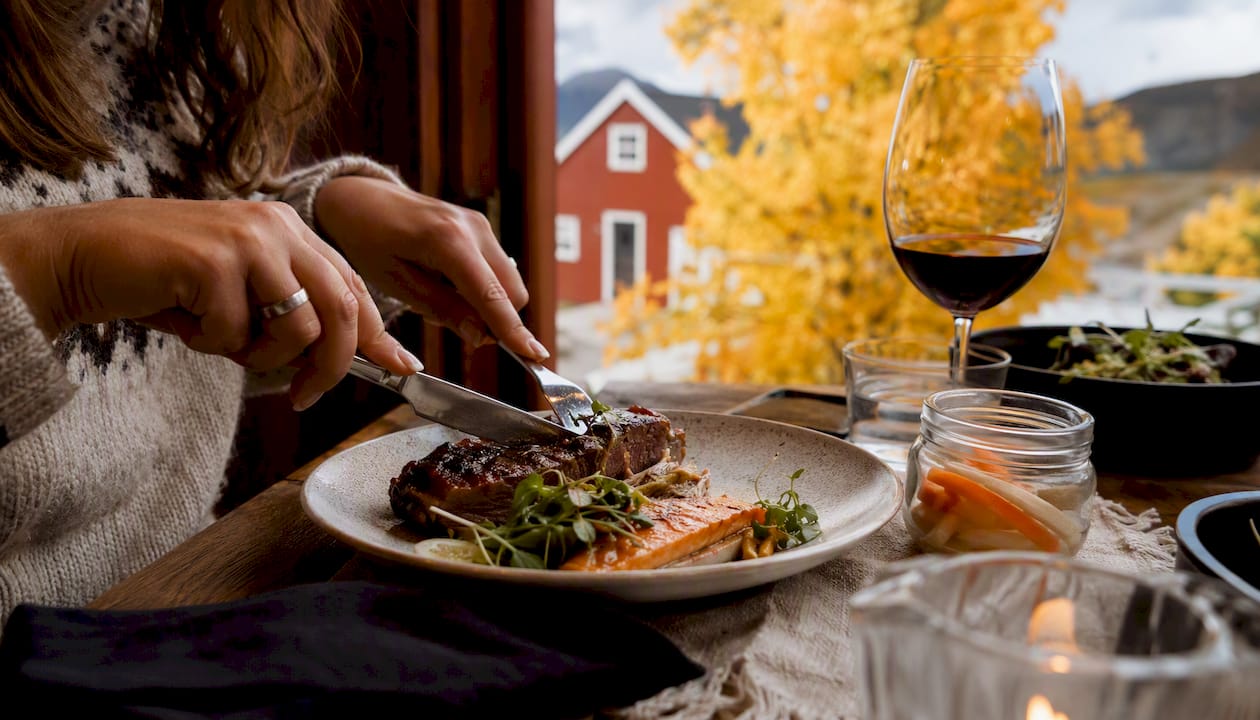 Close-up of hands serving Icelandic lamb and seafood dish