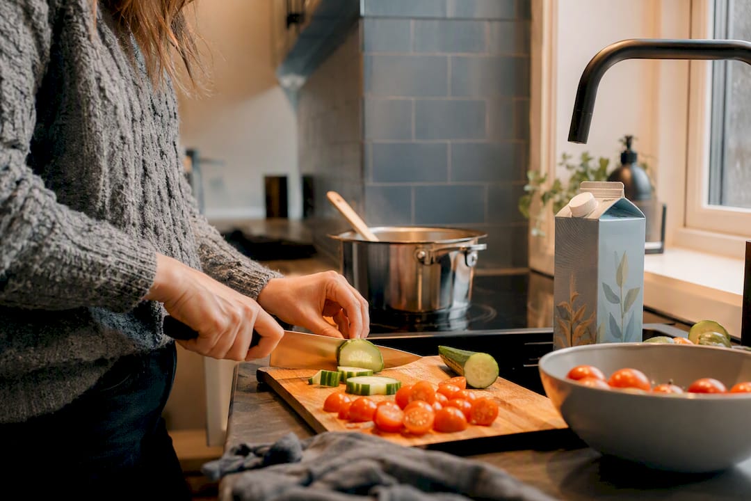 Traveler preparing vegan meal in hostel kitchen