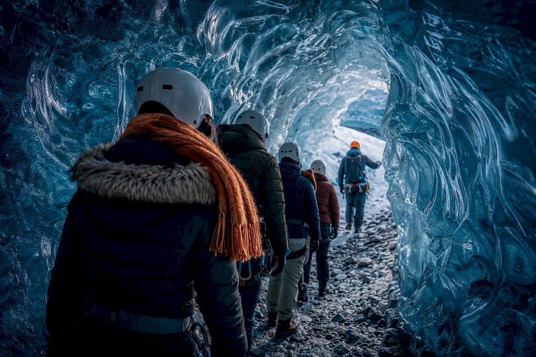Guided visitors inside a blue glacier ice cave
