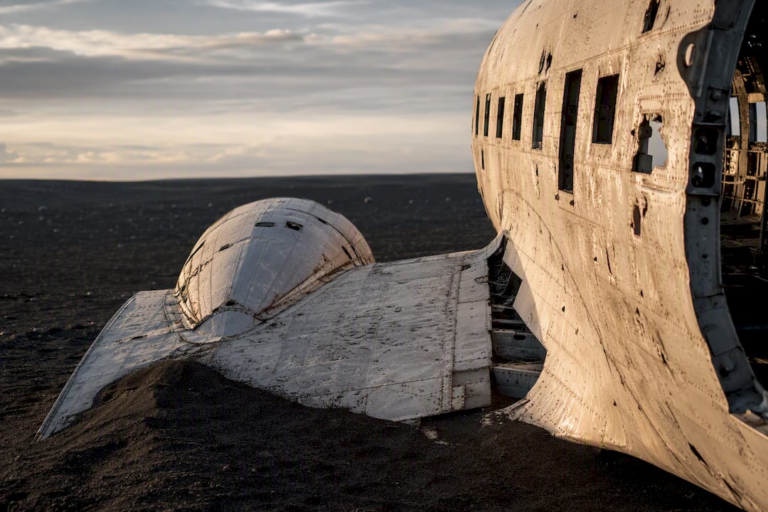 Weathered plane wreck on black sand