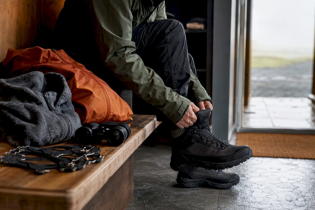 Traveler preparing waterproof layers and boots